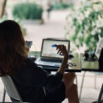 Donna al lavoro con PC e smartphone