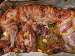 Coniglio arrosto intero avvolto nella pancetta