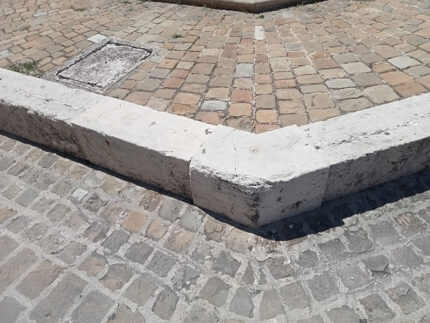 Fontana delle Oche, seduta in pietra abrasa da veicoli parcheggiati